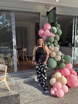 A person standing in front of a large balloon arch AI-generated content may be incorrect.