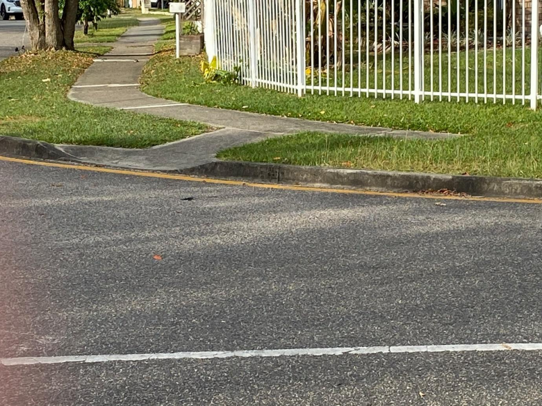 A road with a white fence and grass AI-generated content may be incorrect.