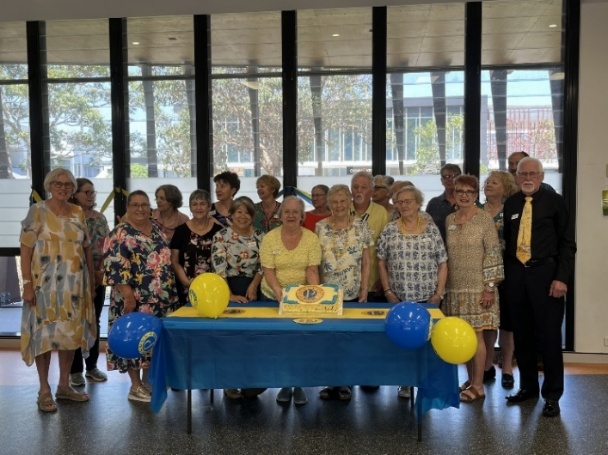 A group of people standing around a table AI-generated content may be incorrect.