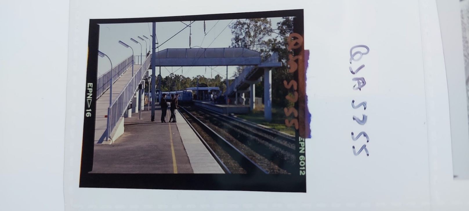 A train station with people standing on the platform AI-generated content may be incorrect.